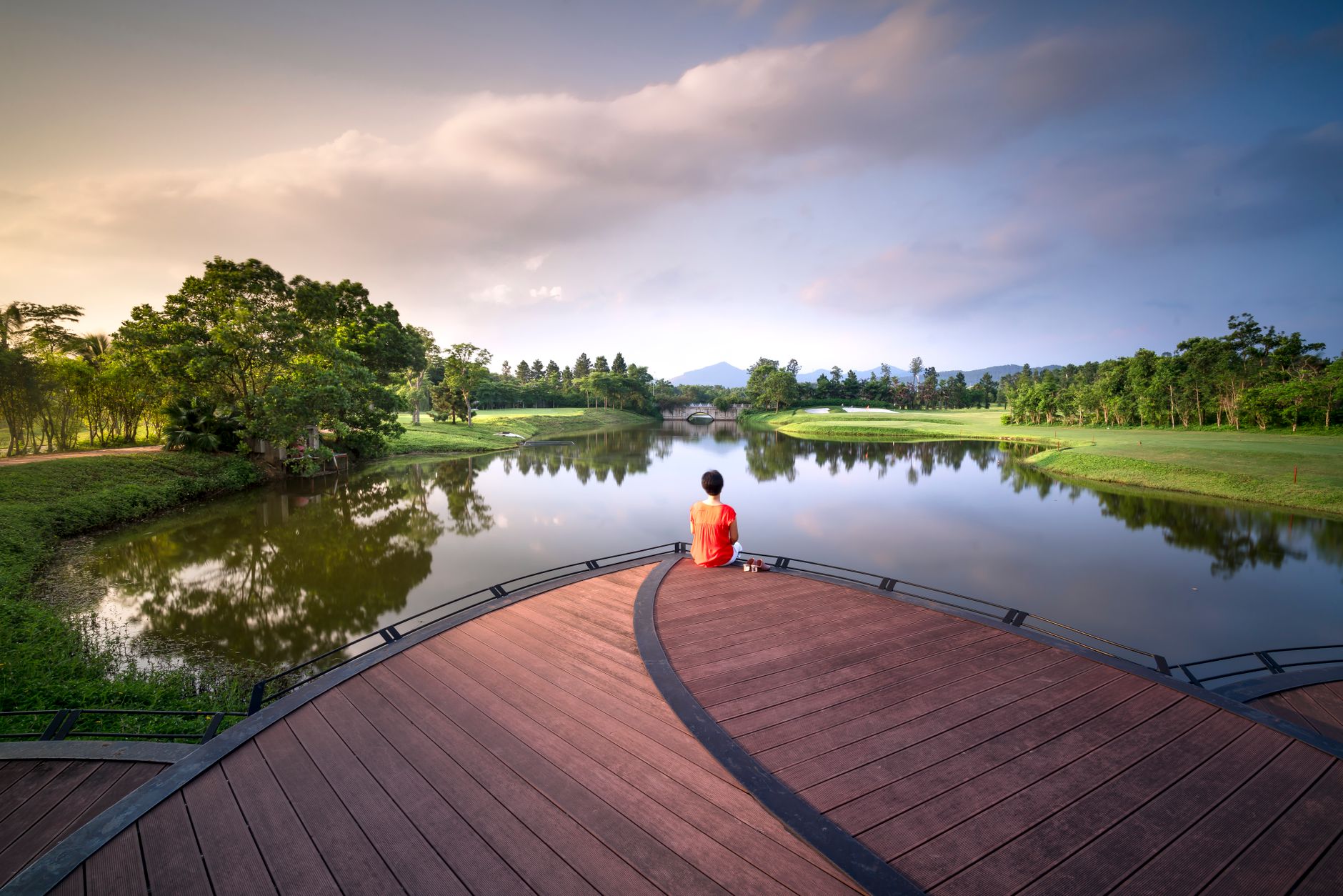 Người ngồi tĩnh lặng bên hồ nước lúc bình minh