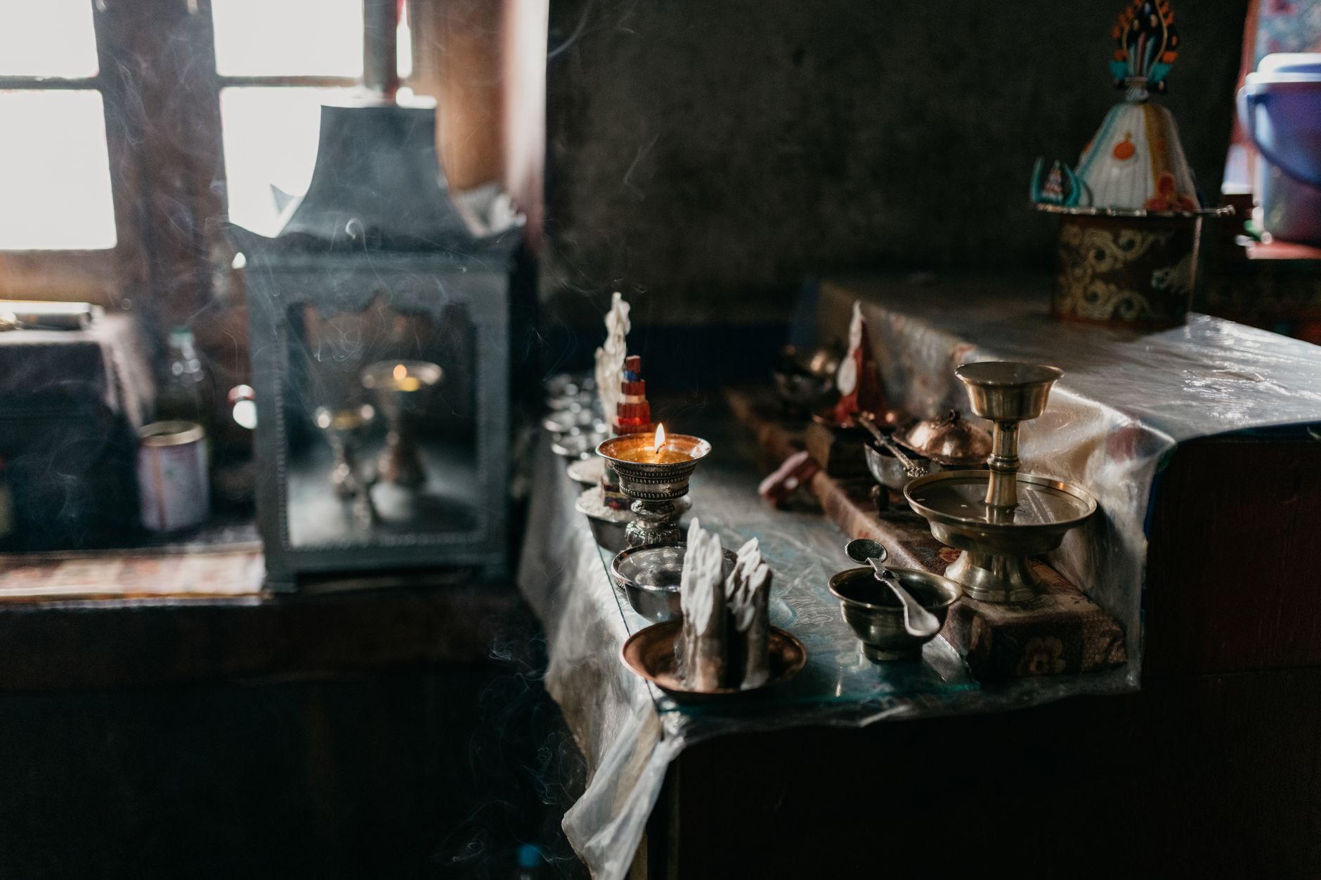 Bàn thờ Phật với chén nước cúng dường và nến trang nghiêm